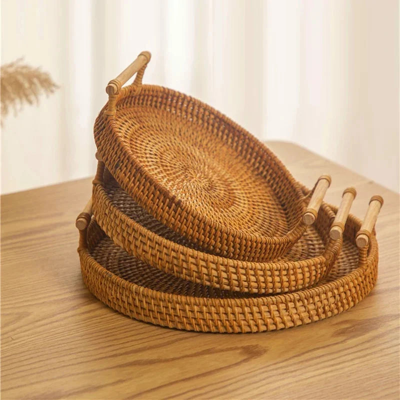3 cestos de palha de vime rattan com alça empilhados sobre mesa de madeira
